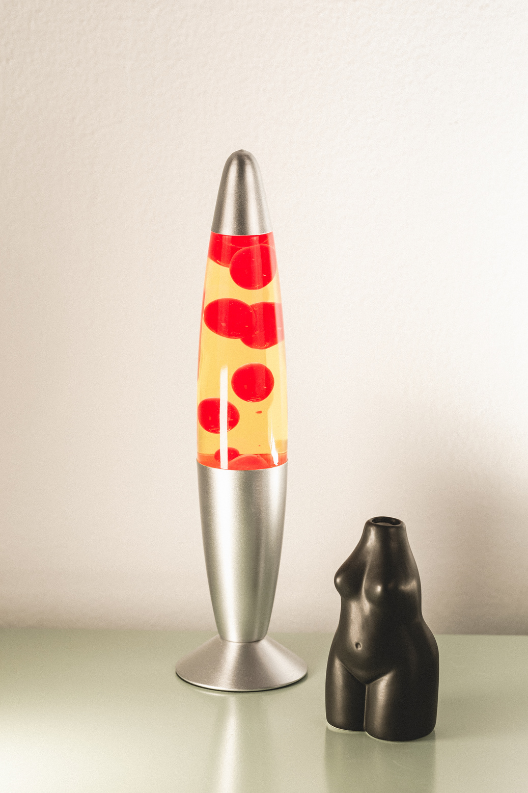 Lava Lamp and Body Statue on Glass Table